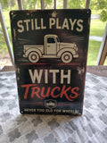 Still Plays With Trucks metal sign